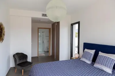 a bedroom with a blue bed and a chair at Domaine d'Arca - Hugo 13 - 6 pers in Porto-Vecchio