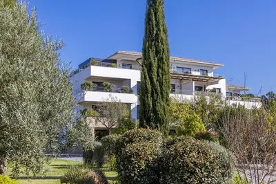 a white apartment building with a large tree at Domaine d'Arca - Hugo 13 - 6 pers in Porto-Vecchio