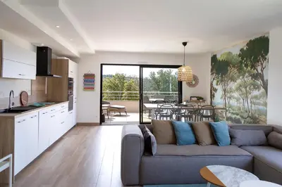 a living room with a couch and a kitchen at Domaine d'Arca - Hugo 09 - 6 pers - « Les Charmes » in Porto-Vecchio