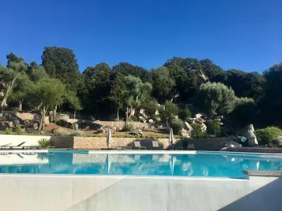 a swimming pool with trees in the background at Domaine d'Arca - Hugo 09 - 6 pers - « Les Charmes » in Porto-Vecchio
