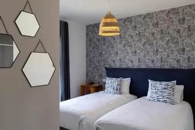 a bedroom with two beds and a pendant light at Domaine d'Arca - Hugo 09 - 6 pers - « Les Charmes » in Porto-Vecchio