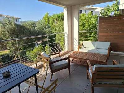 a balcony with chairs and a table and a couch at Résidence Domaine d'Arca Porto Vecchio - T2 haut standing - 4 personnes 