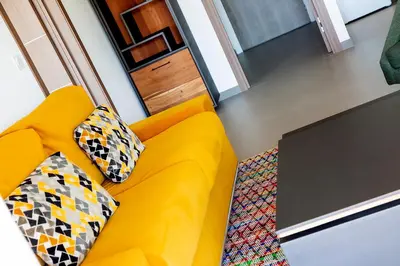 a yellow couch with two pillows in a living room at Résidence Domaine d'Arca Porto Vecchio - T2 haut standing - 4 personnes 
