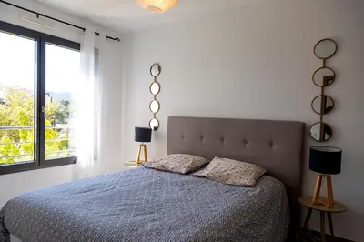 a bedroom with a bed with two lamps and a window at Résidence Domaine d'Arca Porto Vecchio - T2 haut standing - 4 personnes 