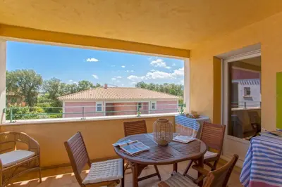 a balcony with a table and chairs and a large window at Casa Chjara Maria in Vescovato