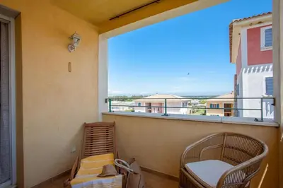 a balcony with a large window and a chair at Casa Chjara Maria in Vescovato