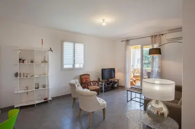 a living room with a table and chairs and a television at Casa Chjara Maria in Vescovato