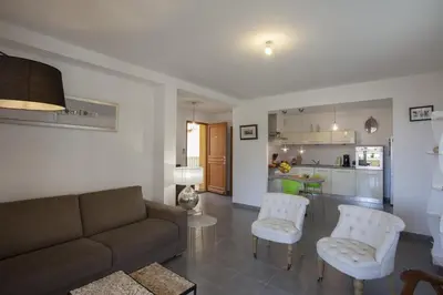 a living room with a couch and chairs and a kitchen at Casa Chjara Maria in Vescovato