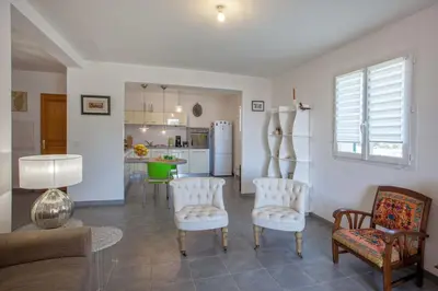 a living room with a couch and chairs and a kitchen at Casa Chjara Maria in Vescovato