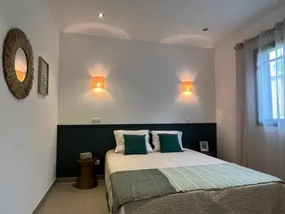 a bedroom with a bed with a red wall at Résidence Storia di Blue in Porto-Vecchio