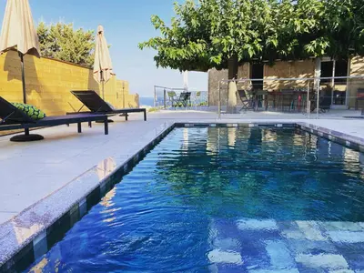a swimming pool with two chairs and an umbrella at Casa Santa Giulia in Propriano