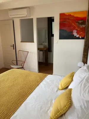 a bedroom with a bed with yellow pillows and a painting at Casa Santa Giulia in Propriano