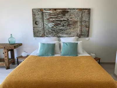a bedroom with a bed with two blue pillows at Casa Santa Giulia in Propriano