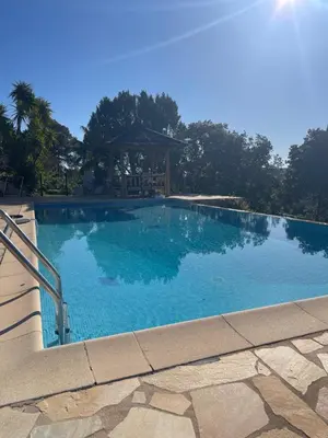 a large blue swimming pool with a gazebo at Casa Mathilde in Lecci