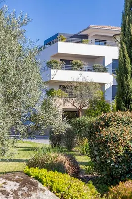 a white building with a garden in front of it at Domaine d'Arca - Eluard 10 - 3 pers in Porto-Vecchio