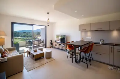 a kitchen and living room with a table and chairs at Domaine d'Arca - Eluard 10 - 3 pers in Porto-Vecchio