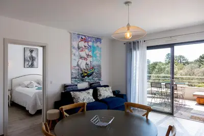 a living room with a bed and a dining room table at Domaine d'Arca - Aragon 11 - 4 pers - « Au jardin d'Arca » in Porto-Vecchio
