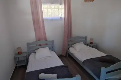 two beds in a small room with a window at F4 à Porticcio avec piscine et vue sur mer in Porticcio