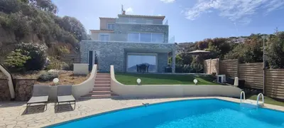 a villa with a swimming pool in front of a house at F4 à Porticcio avec piscine et vue sur mer in Porticcio