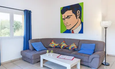 a living room with a couch and a painting on the wall at Locations 