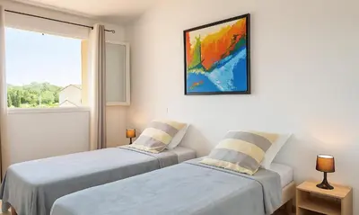 two beds in a room with a window at Locations 