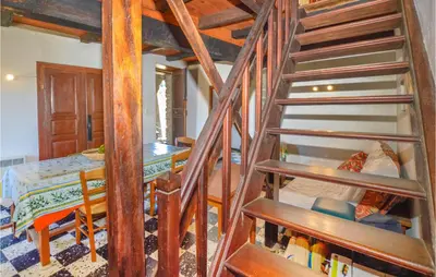 a wooden spiral staircase in a room with a bed at 3 Bedroom Nice Home In Pietra Di Verde in Pietra-di-Verde