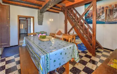 a living room with a table and a staircase at 3 Bedroom Nice Home In Pietra Di Verde in Pietra-di-Verde