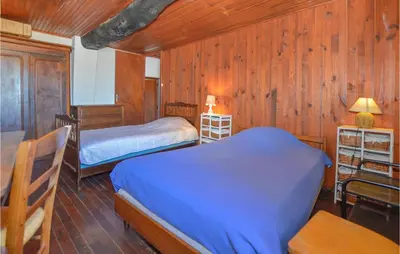 two beds in a room with wood paneled walls at 3 Bedroom Nice Home In Pietra Di Verde in Pietra-di-Verde