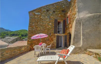 a patio with a table and chairs and an umbrella at 3 Bedroom Nice Home In Pietra Di Verde in Pietra-di-Verde
