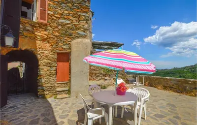 a table and chairs with an umbrella on a patio at 3 Bedroom Nice Home In Pietra Di Verde in Pietra-di-Verde