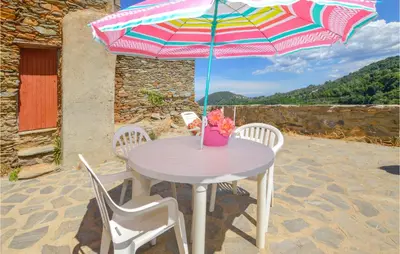 a table with a colorful umbrella on a patio at 3 Bedroom Nice Home In Pietra Di Verde in Pietra-di-Verde