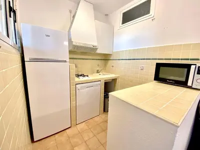 a kitchen with a white refrigerator and a sink at Les Roches de Figa in Conca
