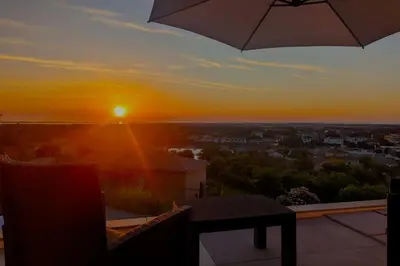 a sunset from a balcony with an umbrella at Casa Dolce Vita in Borgo
