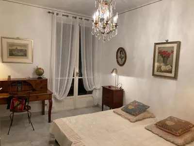 a bedroom with two beds and a desk and a chandelier at AJACCIO VUE MER, 3 chambres, 6 personnes in Ajaccio