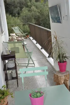 a balcony with a bench and potted plants on it at AJACCIO VUE MER, 3 chambres, 6 personnes in Ajaccio