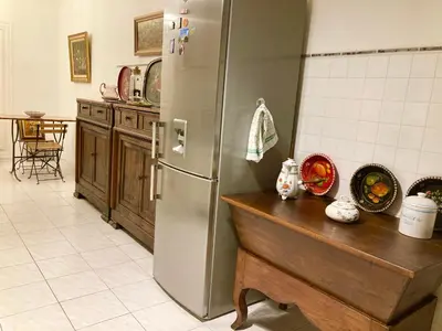 a kitchen with a stainless steel refrigerator and a wooden table at AJACCIO VUE MER, 3 chambres, 6 personnes in Ajaccio
