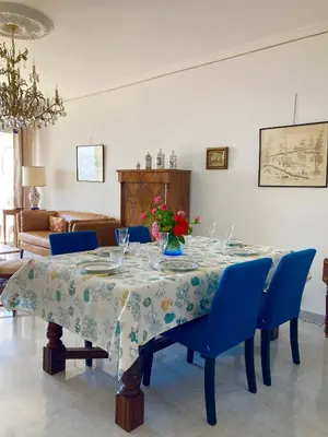 a dining room table with blue chairs and a table cloth at AJACCIO VUE MER, 3 chambres, 6 personnes in Ajaccio