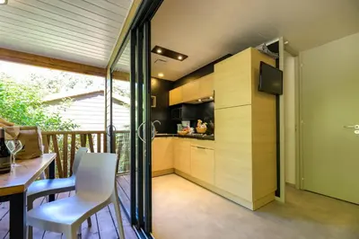 a kitchen and dining area of a house with a balcony at Camping U Pirellu in Porto-Vecchio