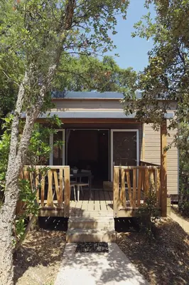 a screened in porch of a house with a table at Camping U Pirellu in Porto-Vecchio