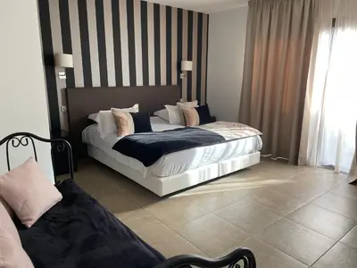 a bedroom with two beds and a large window at Les Bergeries in Ajaccio