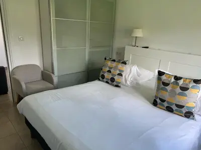 a bedroom with a white bed with a chair at Les Bergeries in Ajaccio