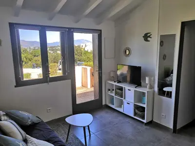 a living room with a couch and a television at Porticcio très joli T2 climatisé & grande terrasse à 1km de la plage in Porticcio