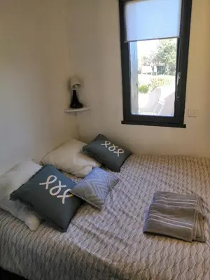 a bedroom with a bed with pillows on it at Porticcio très joli T2 climatisé & grande terrasse à 1km de la plage in Porticcio