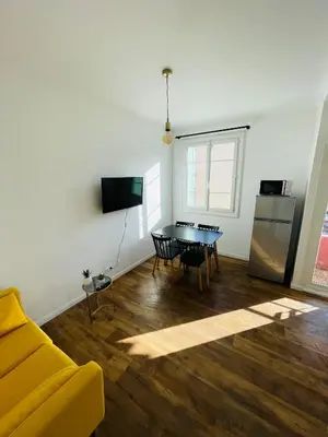 a living room with a yellow couch and a table at Appartement Bonaparte centre ville d'Ajaccio in Ajaccio