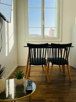two chairs and a table in a room with a window at Appartement Bonaparte centre ville d'Ajaccio in Ajaccio