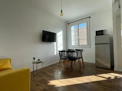 a living room with a kitchen and a table and chairs at Appartement Bonaparte centre ville d'Ajaccio in Ajaccio