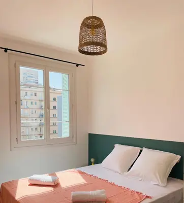 a bedroom with a large bed with a window at Appartement Bonaparte centre ville d'Ajaccio in Ajaccio