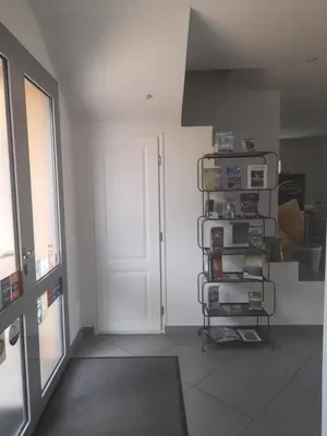 a room with a door and a shelf with books at Chambres d'Hôtes Villa Cardellini in Aullène