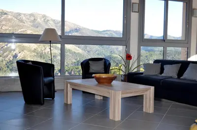 a living room with a coffee table and two chairs at Chambres d'Hôtes Villa Cardellini in Aullène