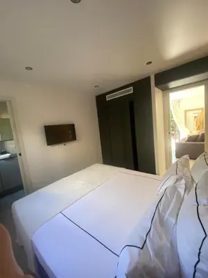 a large white bed in a room with a tv at La Verda in Bonifacio